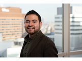 A headshot of Juan Alvarez, an assistant professor of Cell and Developmental Biology, standing in front of a window
